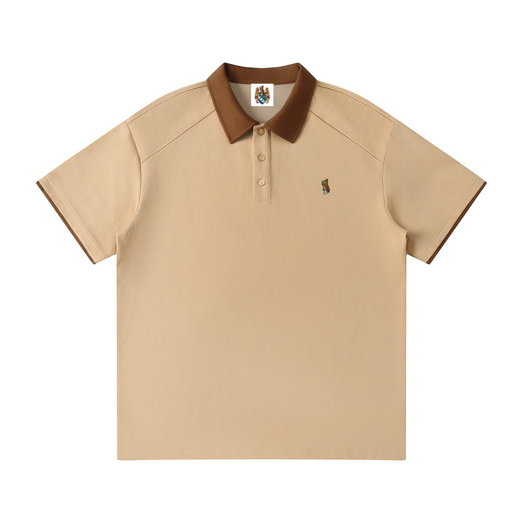 Norman Prince beige cotton blend short sleeve polo shirt with brown collar and sleeve trim, featuring a small embroidered bear graphic.