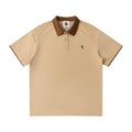 Norman Prince beige cotton blend short sleeve polo shirt with brown collar and sleeve trim, featuring a small embroidered bear graphic.