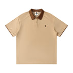 Norman Prince beige cotton blend short sleeve polo shirt with brown collar and sleeve trim, featuring a small embroidered bear graphic.