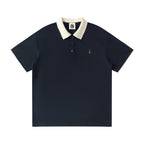Norman Prince navy blue cotton blend short sleeve polo shirt with a contrasting cream collar and sleeve trim, featuring a small embroidered crest.