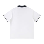 Norman Prince white cotton blend short sleeve polo shirt with navy collar and sleeve trim.